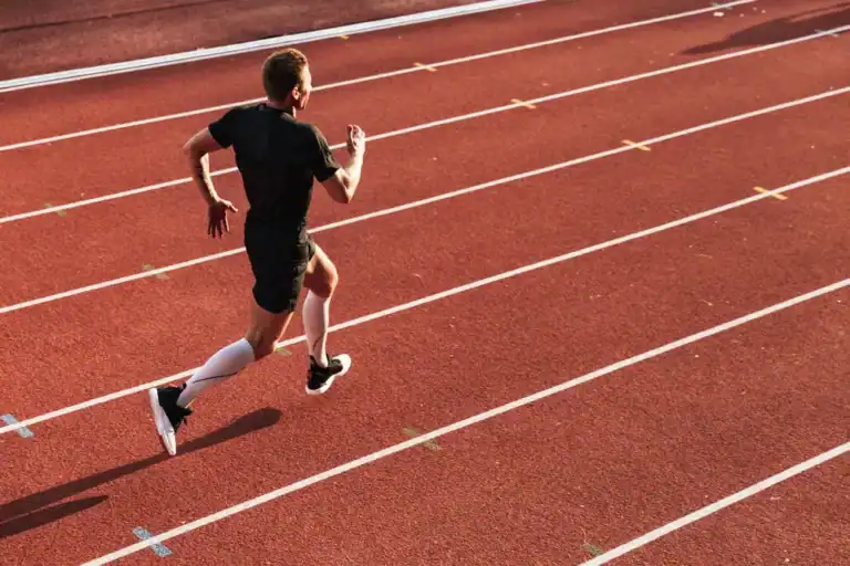 Runner sprinting on outdoor track.