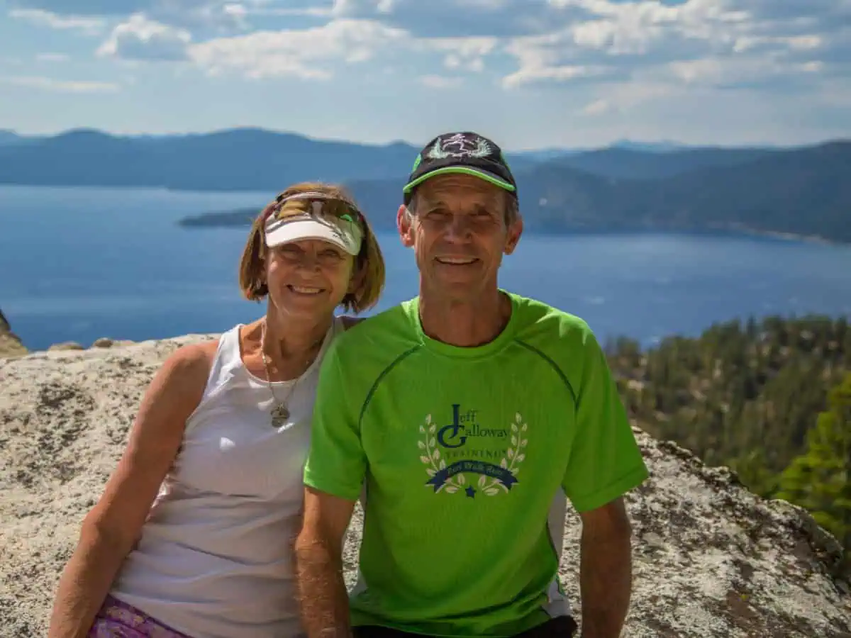 Couple hiking with scenic lake view background
