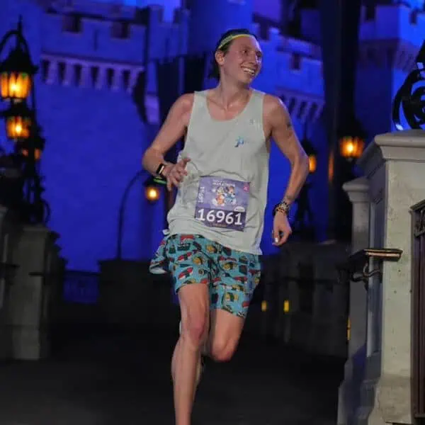 Runner wearing race bib 16961 jogging on themed course